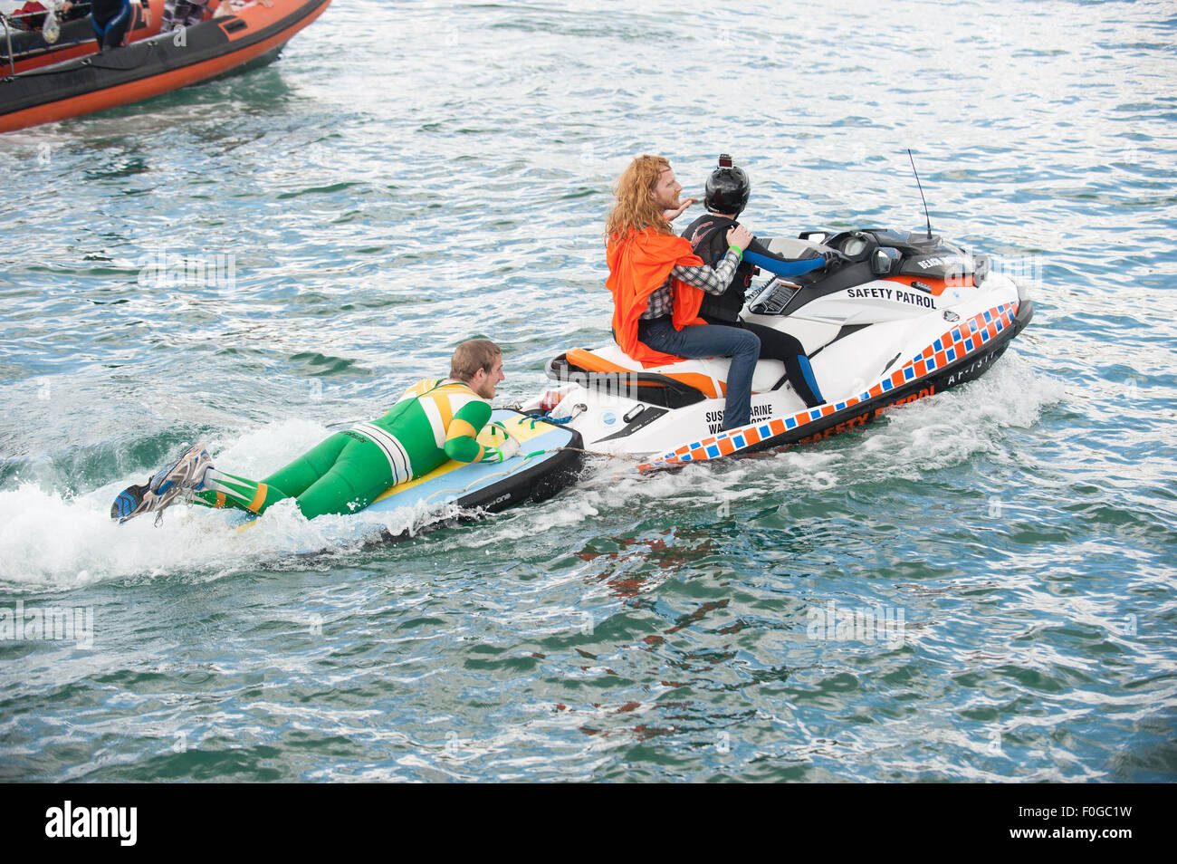 Worthing, Regno Unito. Il 15 agosto, 2015. Il team di sicurezza di portare i concorrenti torna alla spiaggia. Il Worthing International Birdman Festival 2015 Credit: stephen Bartolomeo/Alamy Live News Foto Stock