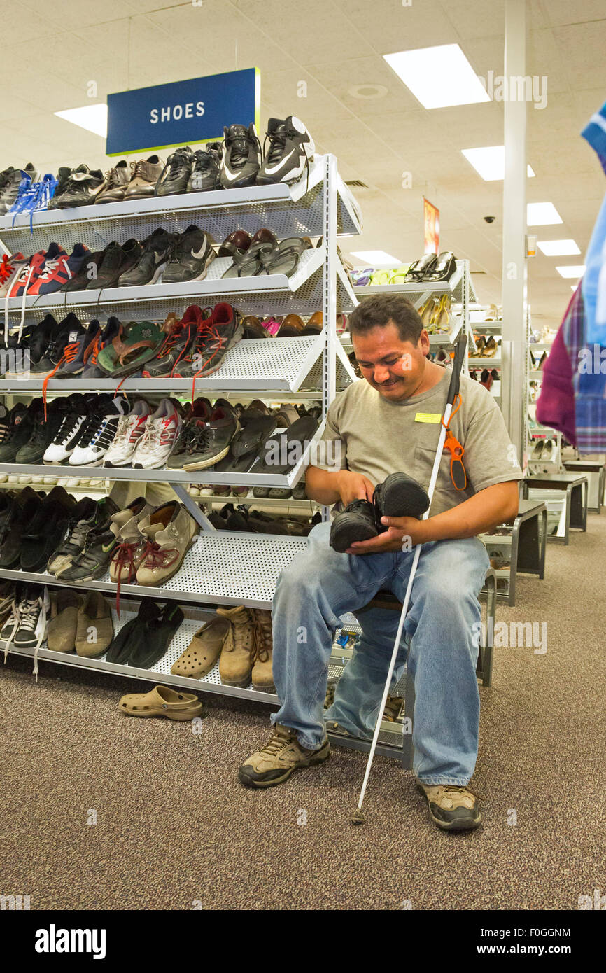 Salt Lake City, Utah - un uomo cieco cerca calzature in corrispondenza della Industrie Deseret' parsimonia store. Foto Stock