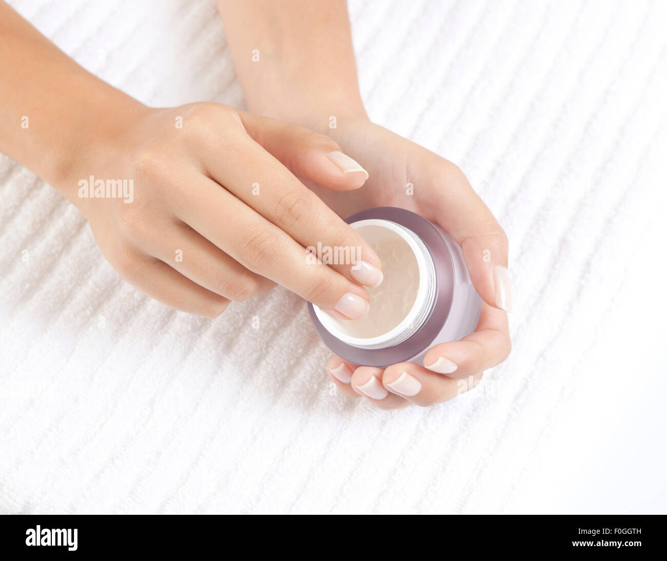 Donna di mani tenendo una crema nutriente per la cura del viso Foto Stock