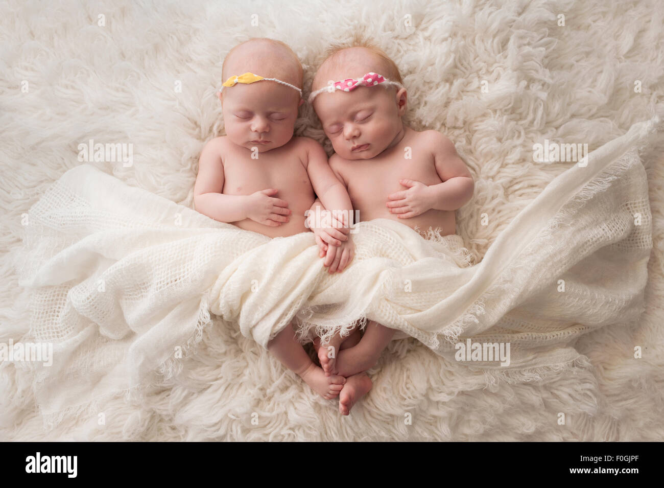 Sette settimane vecchio fraterna, twin baby ragazze dormire su un bianco flokati rug. Foto Stock