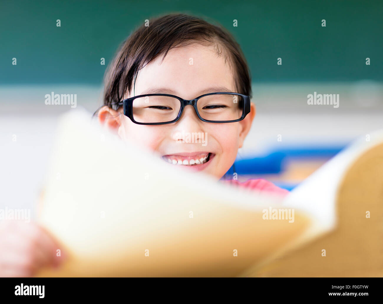 Felice bambina studiare in classe Foto Stock