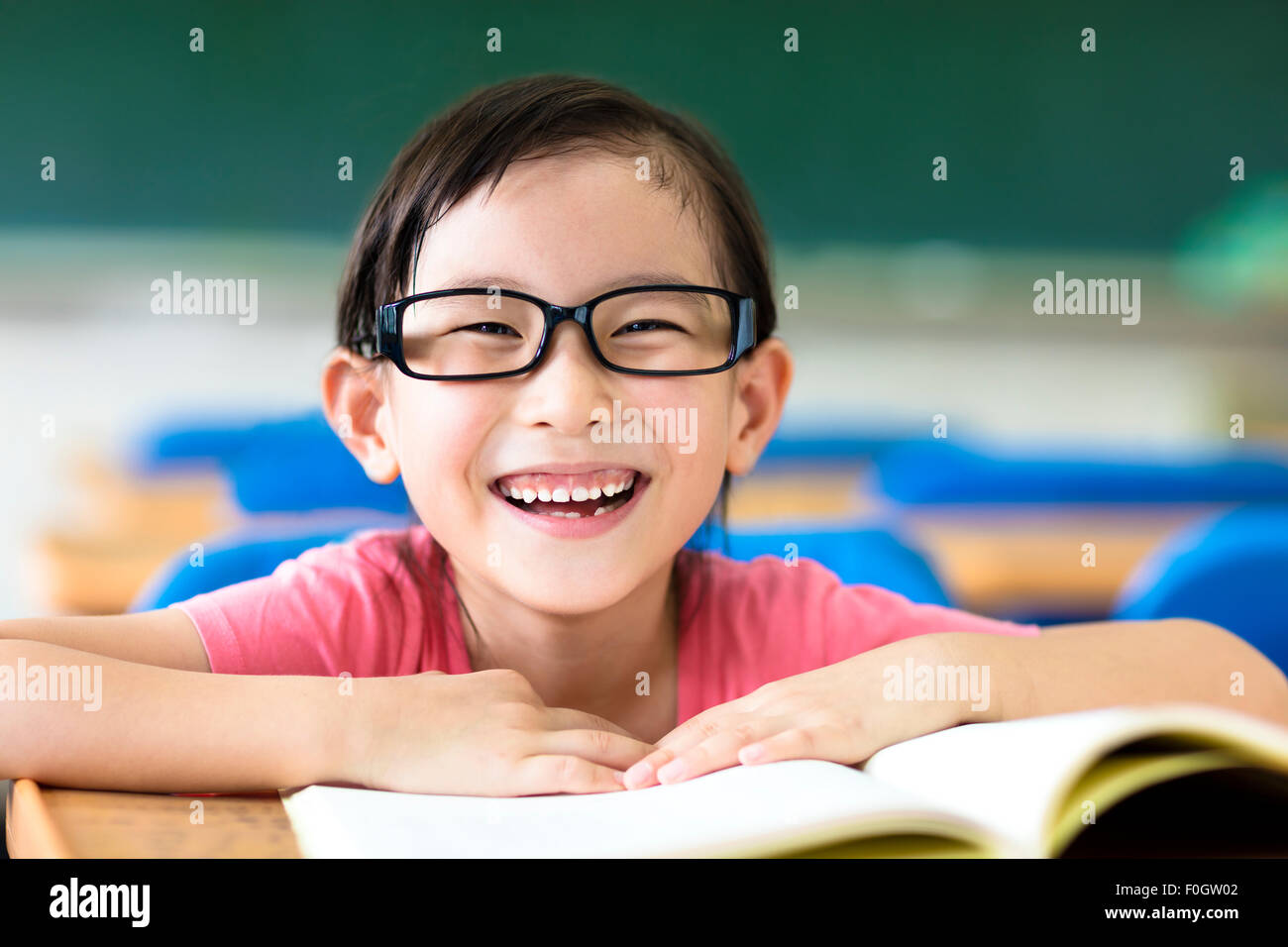 Felice bambina studiare in classe Foto Stock