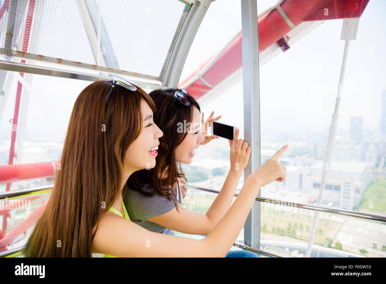 Le fanciulle felici di prendere foto in La ruota panoramica Ferris Foto Stock