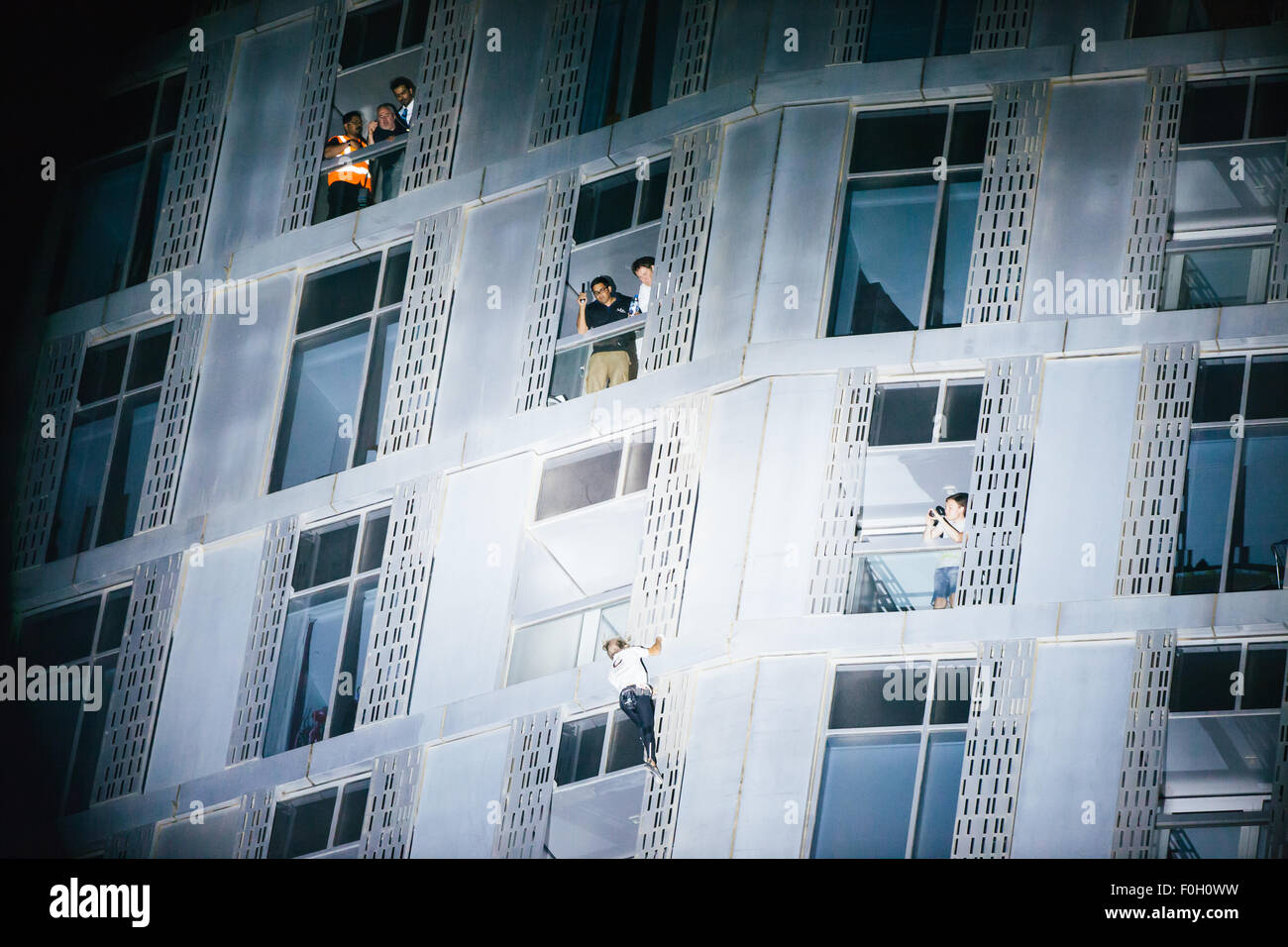 Alain Robert - noto anche come uomo Spiderman - arrampicata Cayman Tower a Dubai, UAE. Foto Stock