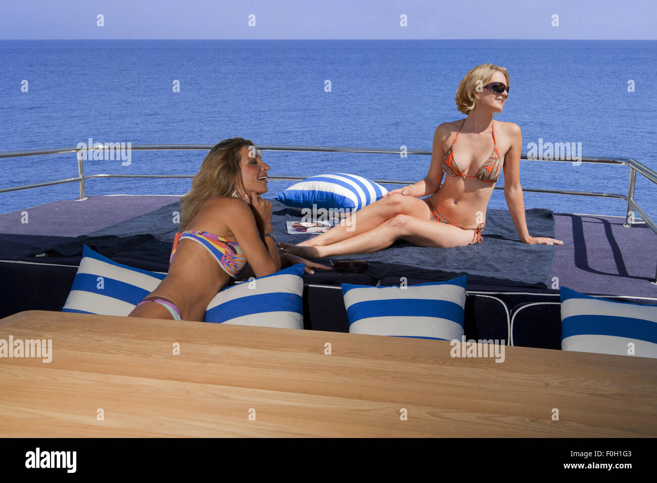 Due giovani donne in chat su uno yacht Foto Stock