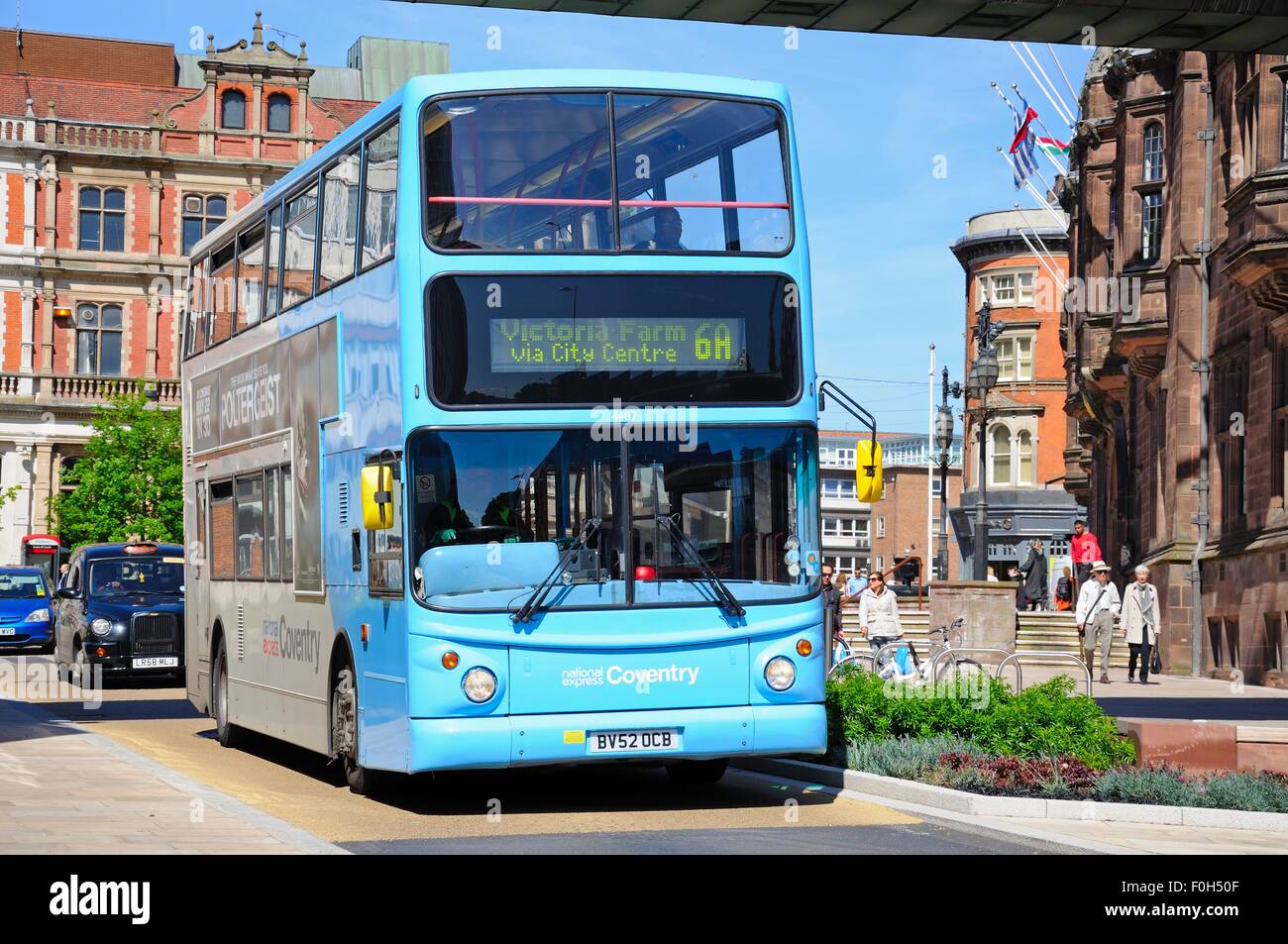 Moderni bus blu passando il Consiglio House, Coventry, West Midlands, Inghilterra, Regno Unito, Europa occidentale. Foto Stock