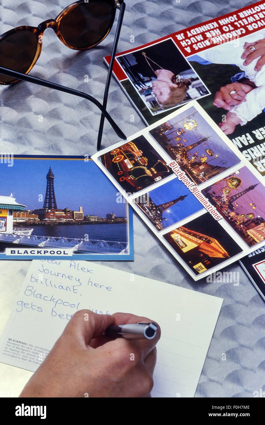 La scrittura di una cartolina da Blackpool. Lancashire. Regno Unito Foto Stock