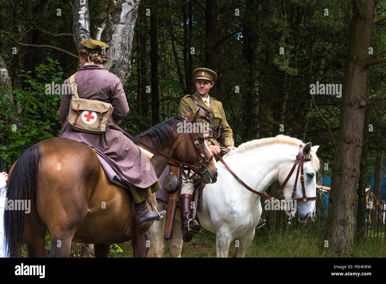 La guerra mondiale una rievocazione soldier e femmina medic cavalcare cavalli da guerra a Cannock Chase Visitor Center Cannock West Midlands, Regno Unito Foto Stock