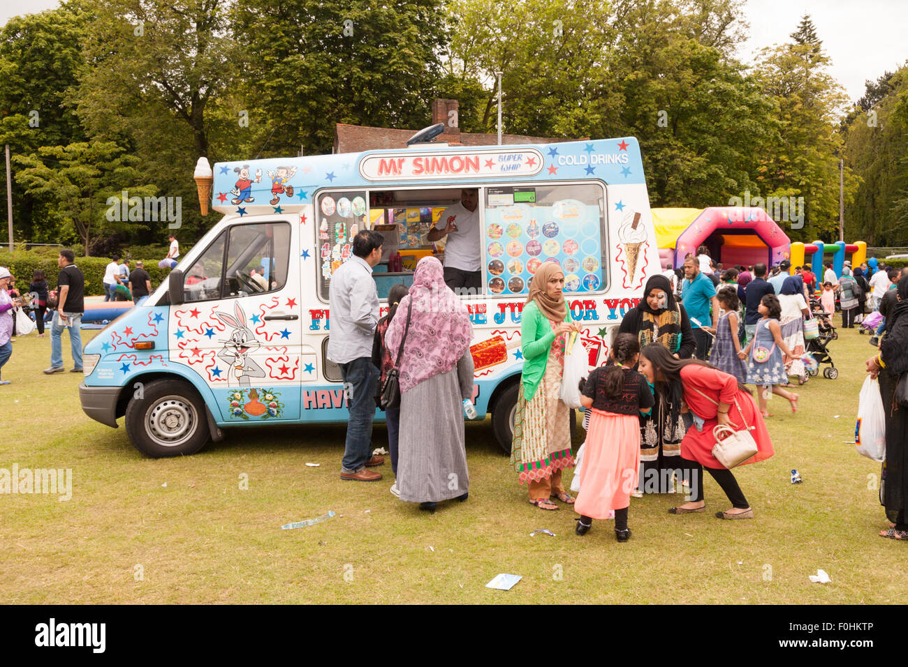 Ice Cream van in un parco a Birmingham Regno Unito con asiatici (pachistani o patrimonio del Bangladesh) persone che acquistano i gelati. Foto Stock