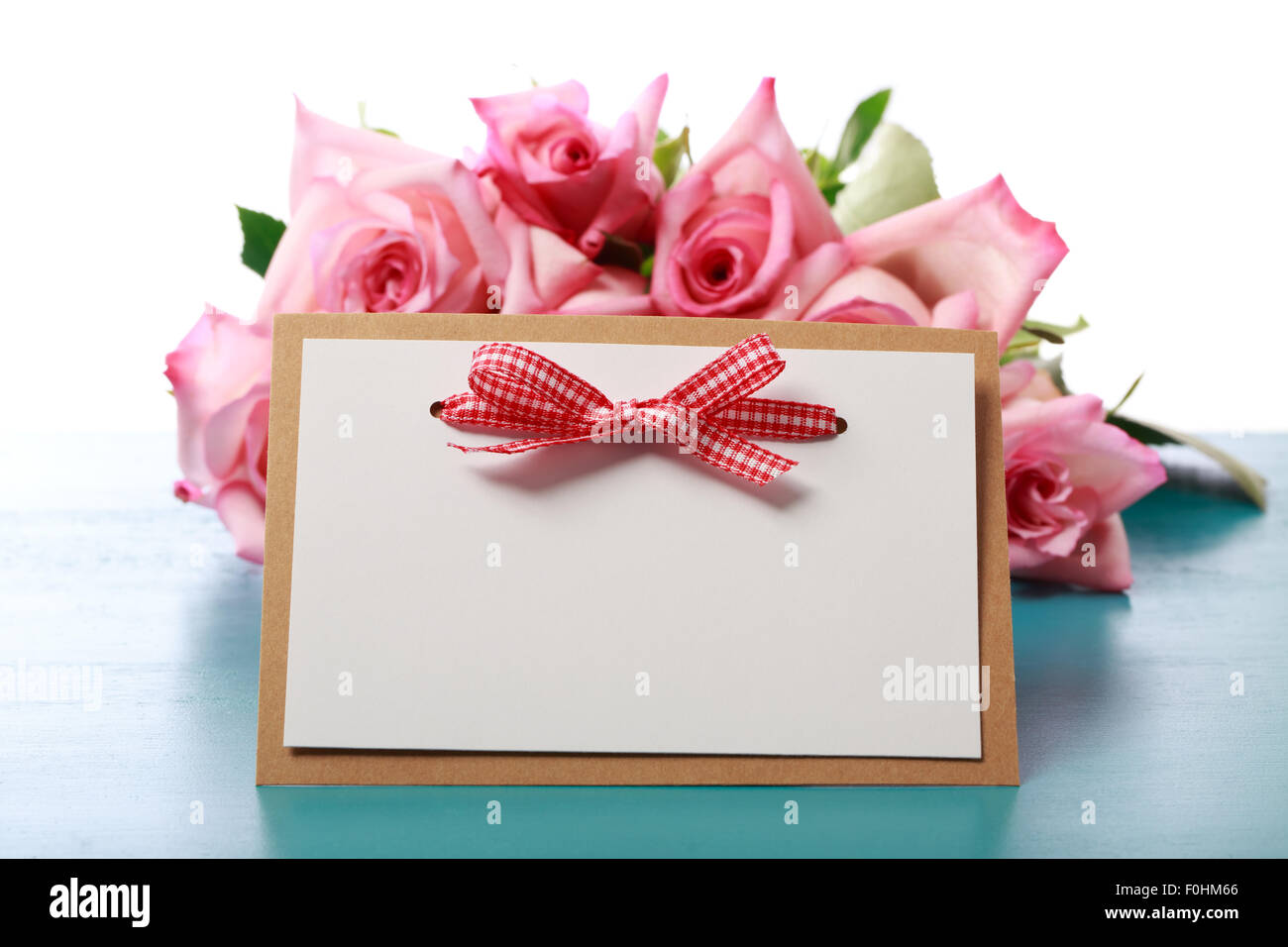 Messaggio fatti a mano carta con le rose rosa su luce blu con bordo in legno Foto Stock