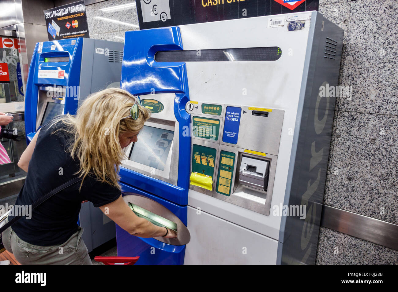 Madrid Spagna,stazione della metropolitana Ispanica Banco de Espana,metropolitana,treno,distributore automatico,donne ispaniche donne,transazione pagamento paga acquisti,ticke Foto Stock