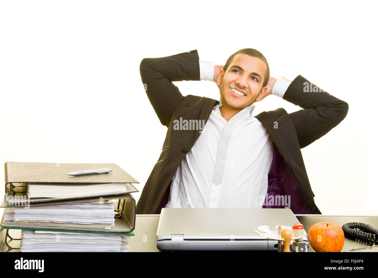 Rilassata uomo d affari con le braccia incrociate dietro la sua testa alla scrivania Foto Stock