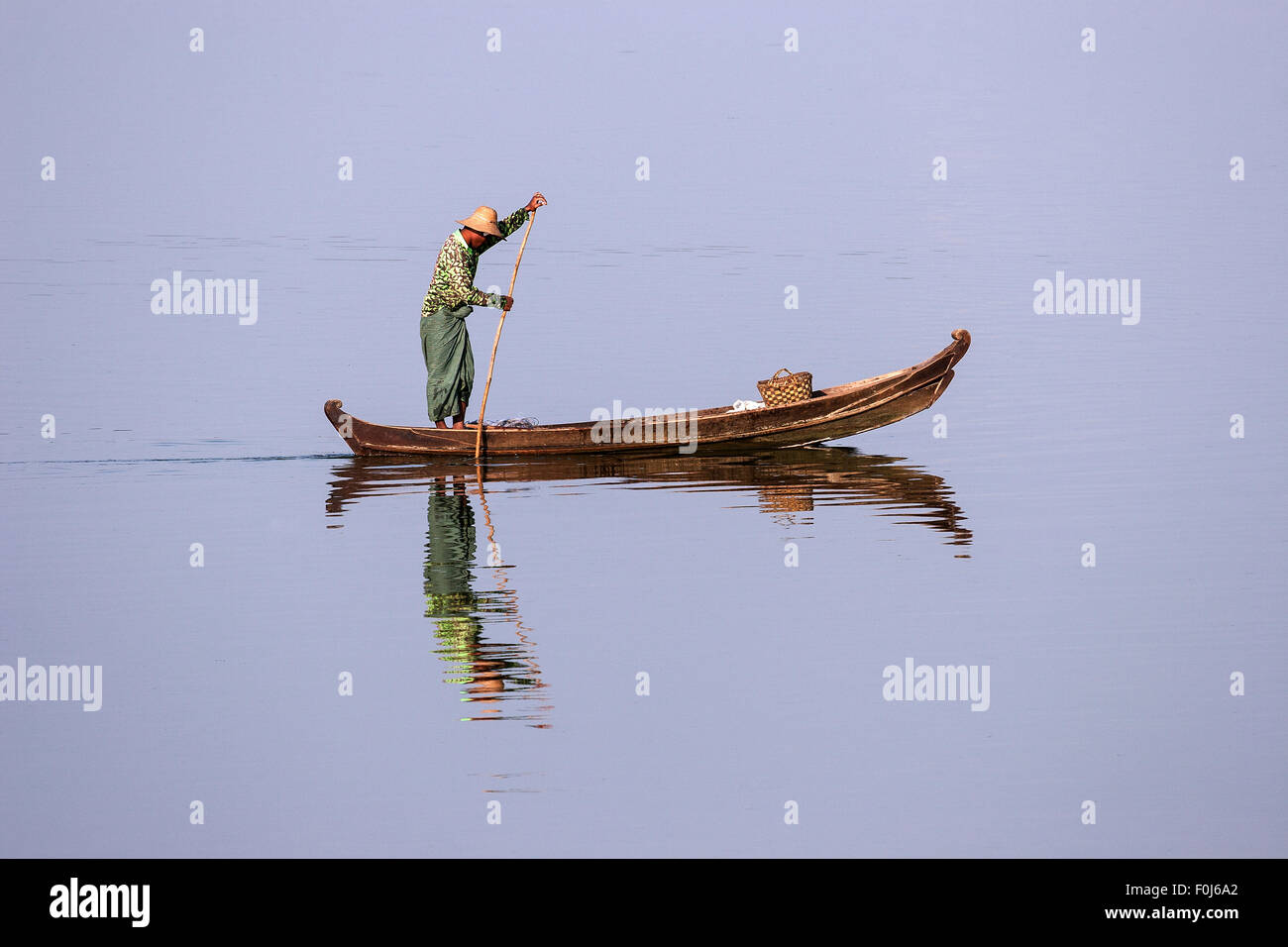Uomo locale su una barca di legno sul lago Taungthaman, Amarapura, Divisione Mandalay, Myanmar Foto Stock