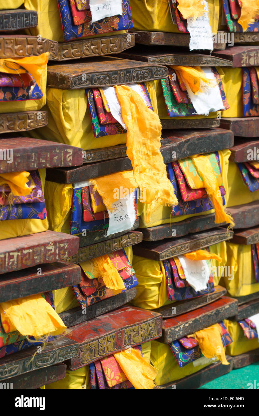 Il legno vecchio scatole contenenti preziosi antichi tibetani e il testo sacro. Ogni boxe è coperto dal giallo, rosso e tessuti di colore blu. Foto Stock