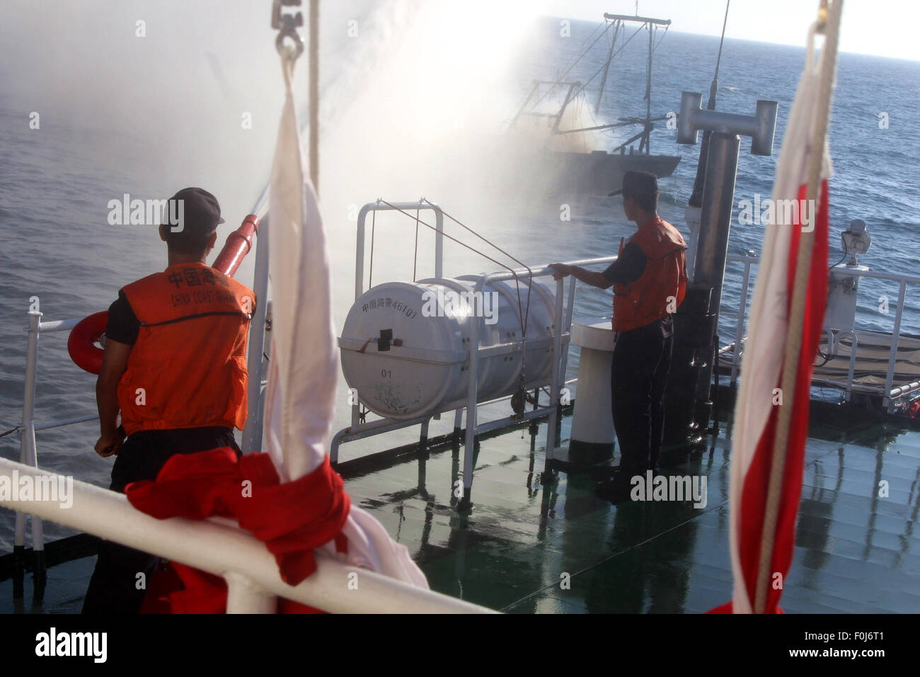 Wenchang, cinese della provincia di Hainan. 17 Ago, 2015. Soccorritori tenta di mettere fuori fuoco di una nave da pesca vela sei miglia nautiche al largo delle coste di Wenchang, Cina del sud della provincia di Hainan, Agosto 17, 2015. Un pescatore è stato intrappolato all'interno della cabina motore e almeno quattro pescatori cadde in mare e devono ancora essere trovati dopo un incendio innescato da esplosione sulla nave da pesca al largo della costa di Hainan lunedì. © Zhang Junzi/Xinhua/Alamy Live News Foto Stock