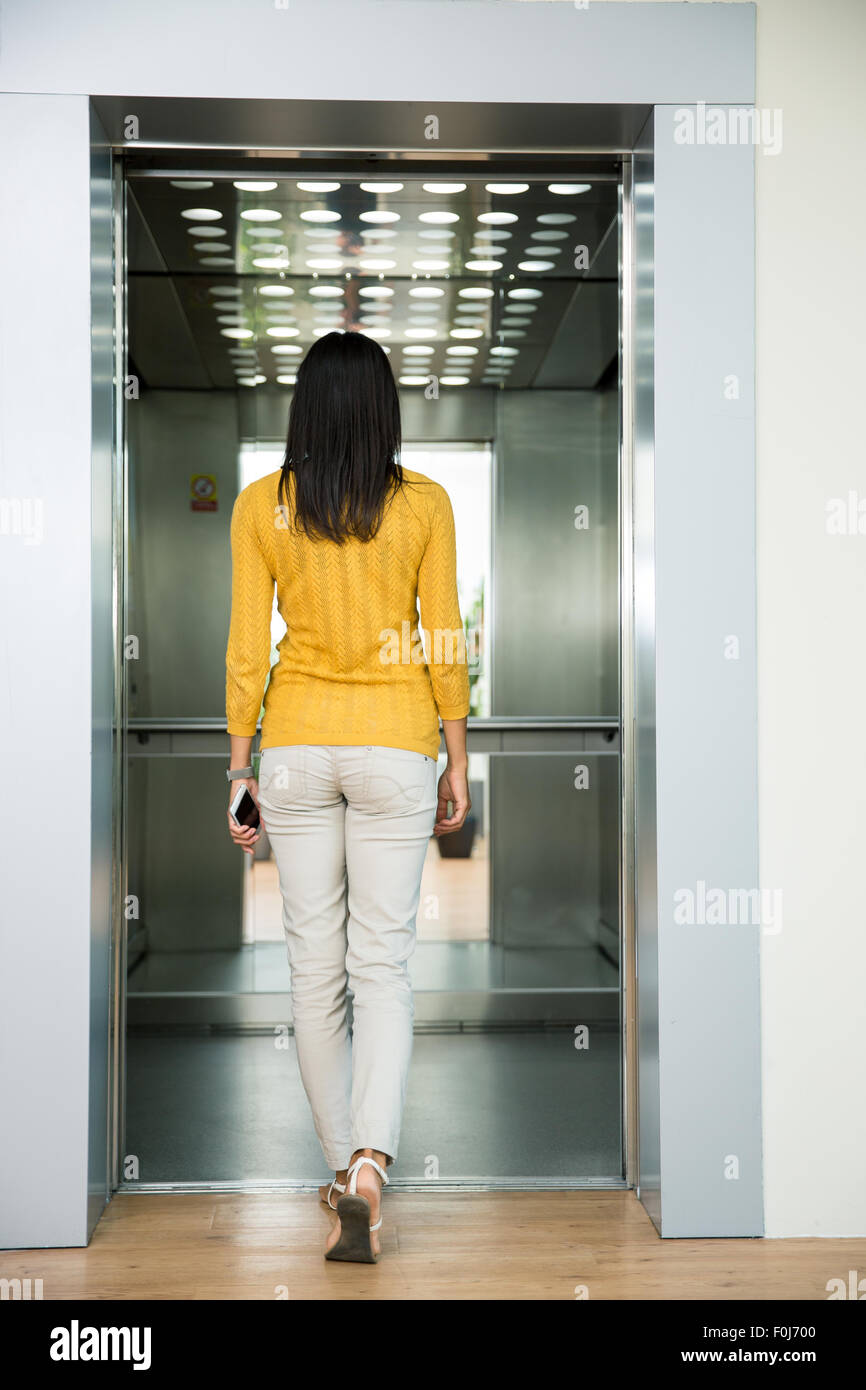 Vista posteriore ritratto di una donna che va in ascensore interni Foto Stock