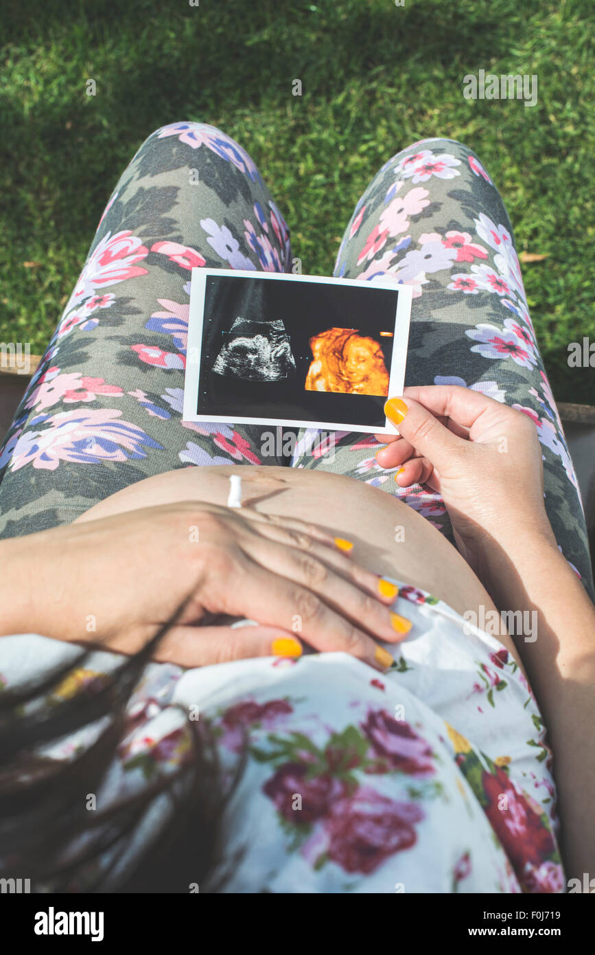 Donne in stato di gravidanza fermo immagine del grembo. La luce diurna in giardino Foto Stock