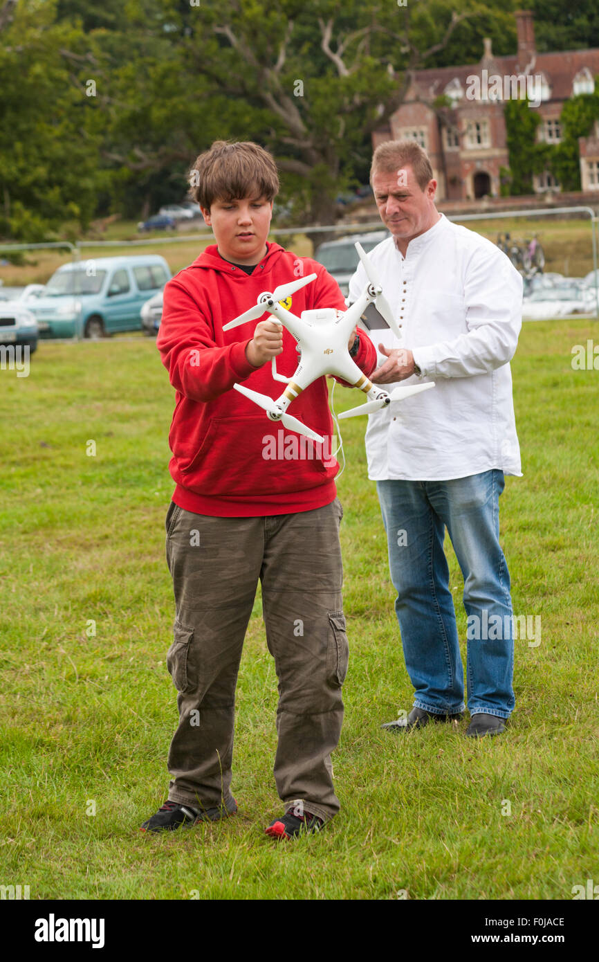 Giovane uomo che opera DJI Phantom drone con fotocamera attaccata al New Forest Fairy Festival, Burley, Hampshire, Regno Unito in agosto Foto Stock