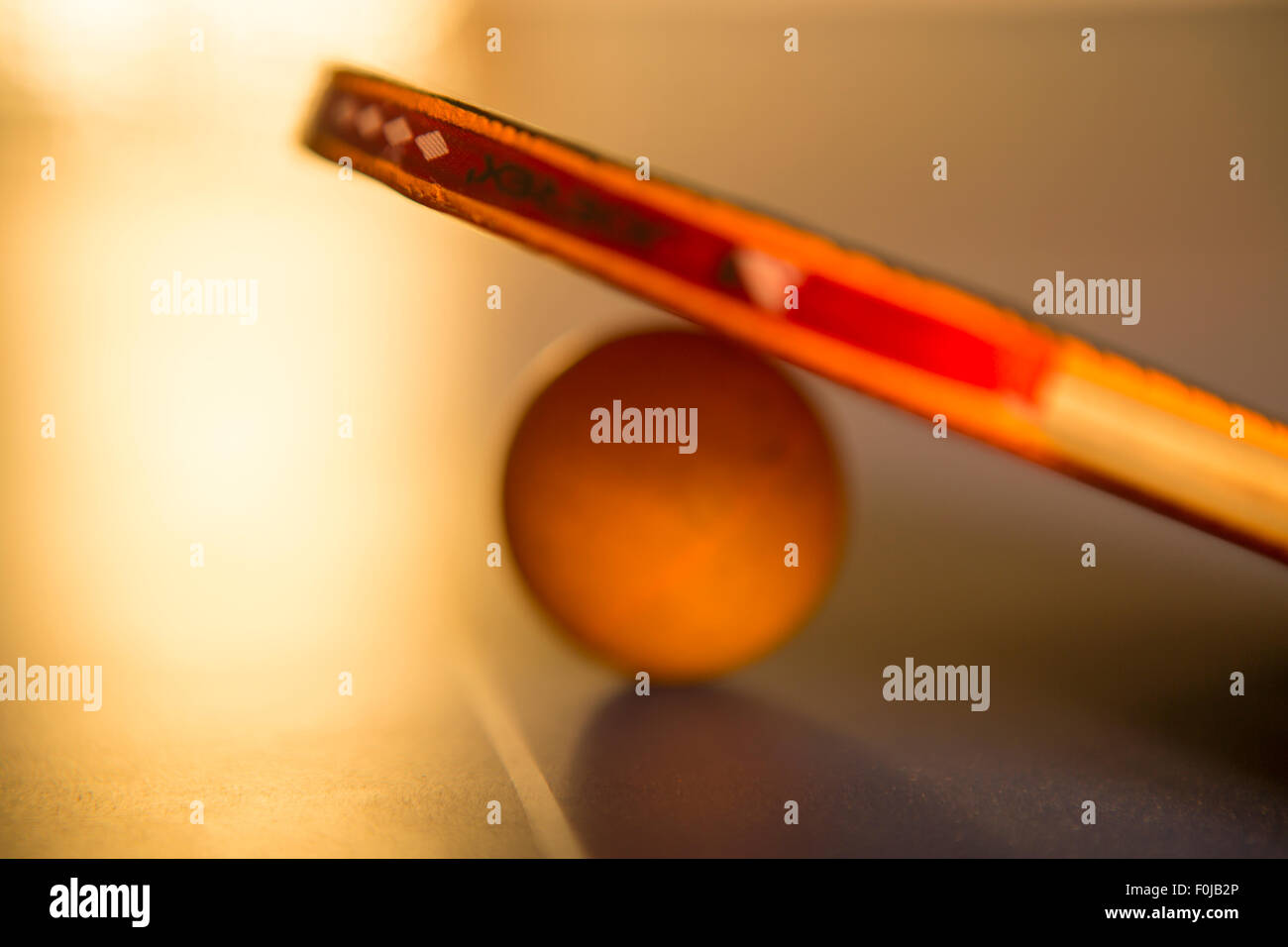 Ping pong palla e racket giacente sul tavolo con sfocati ed effetto artistico Foto Stock