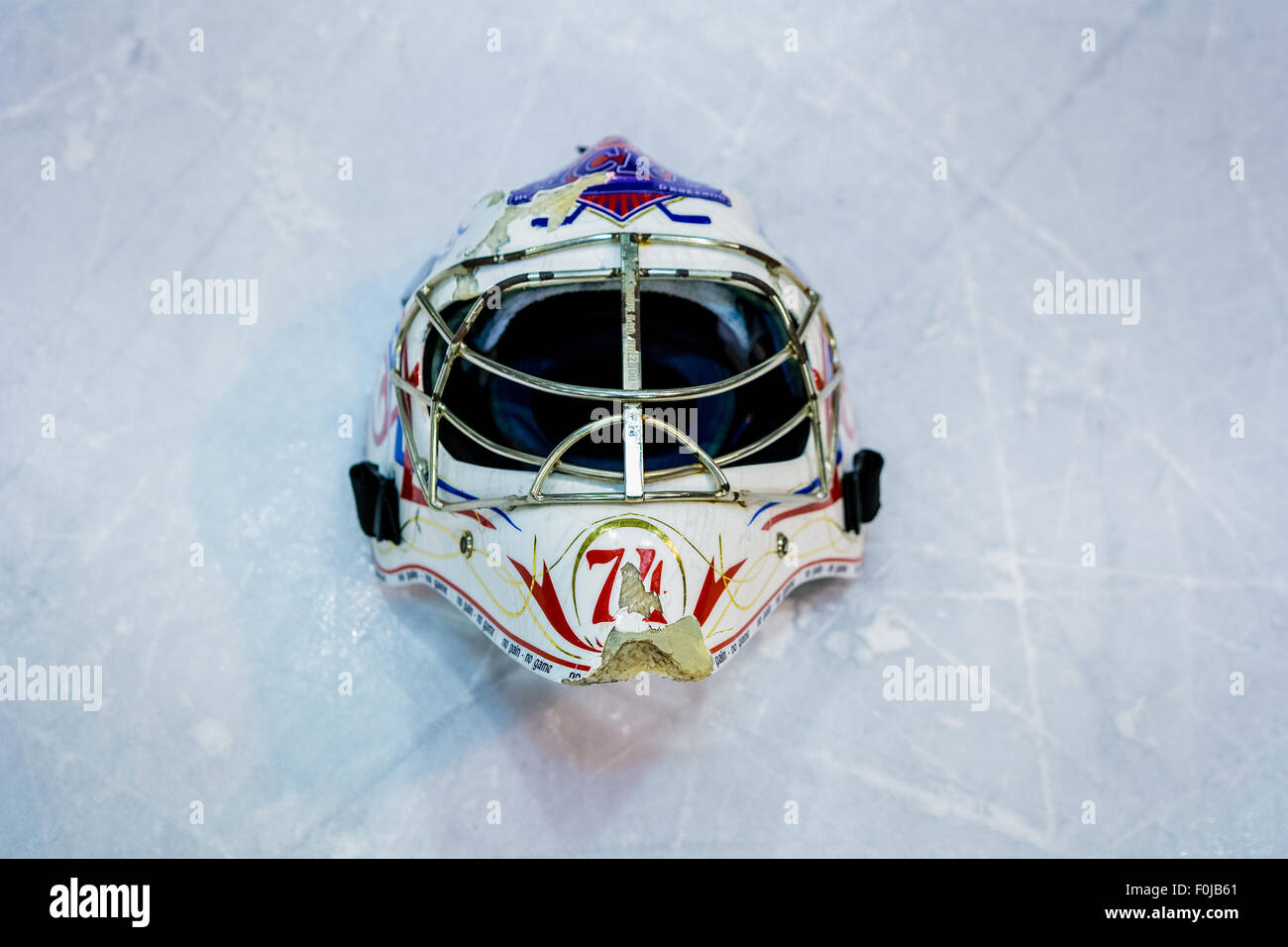 Vecchio goalie casco giacente sul ghiaccio Foto Stock