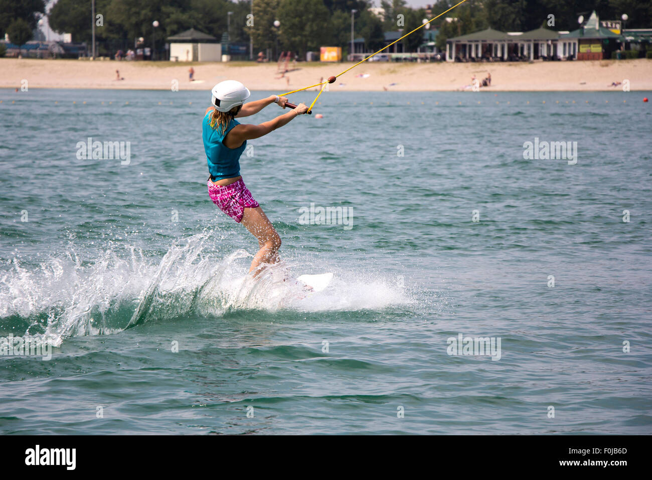 Ragazza giovane wakeboarder in azione sul lago Foto Stock