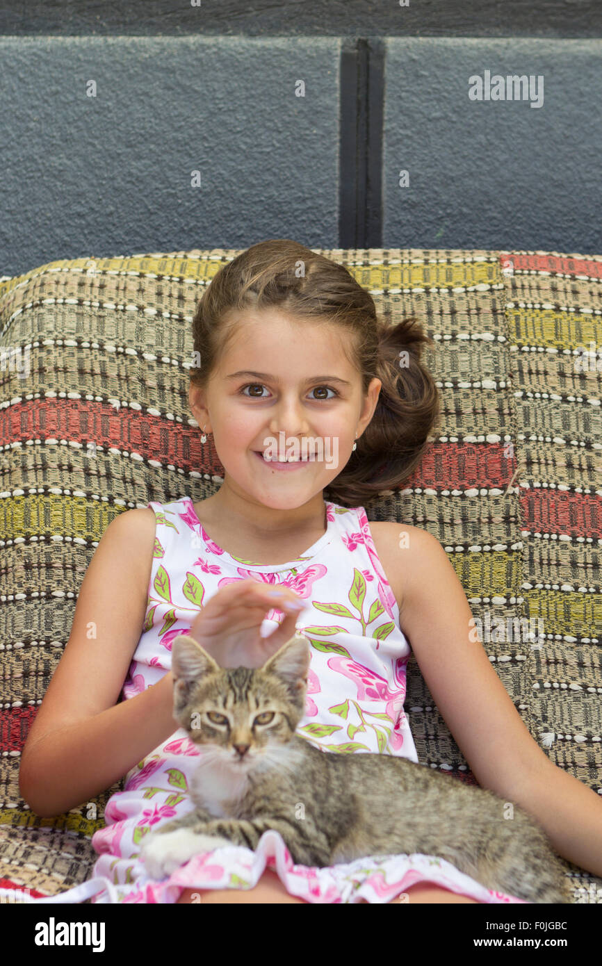 Bella sorridente bambina abbracciando il suo gatto Foto Stock