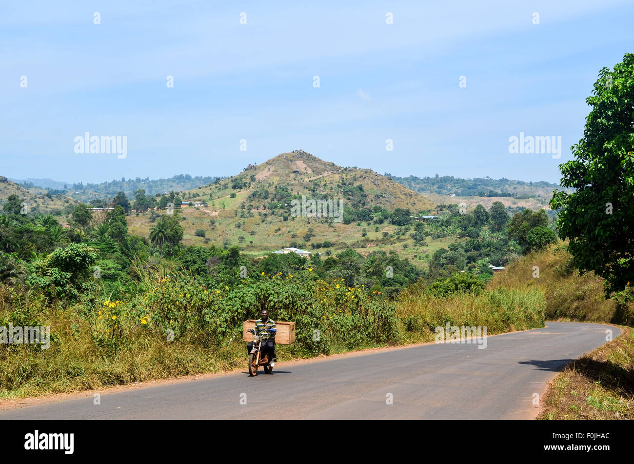 L'uomo africano su una moto su strada in Camerun Foto Stock
