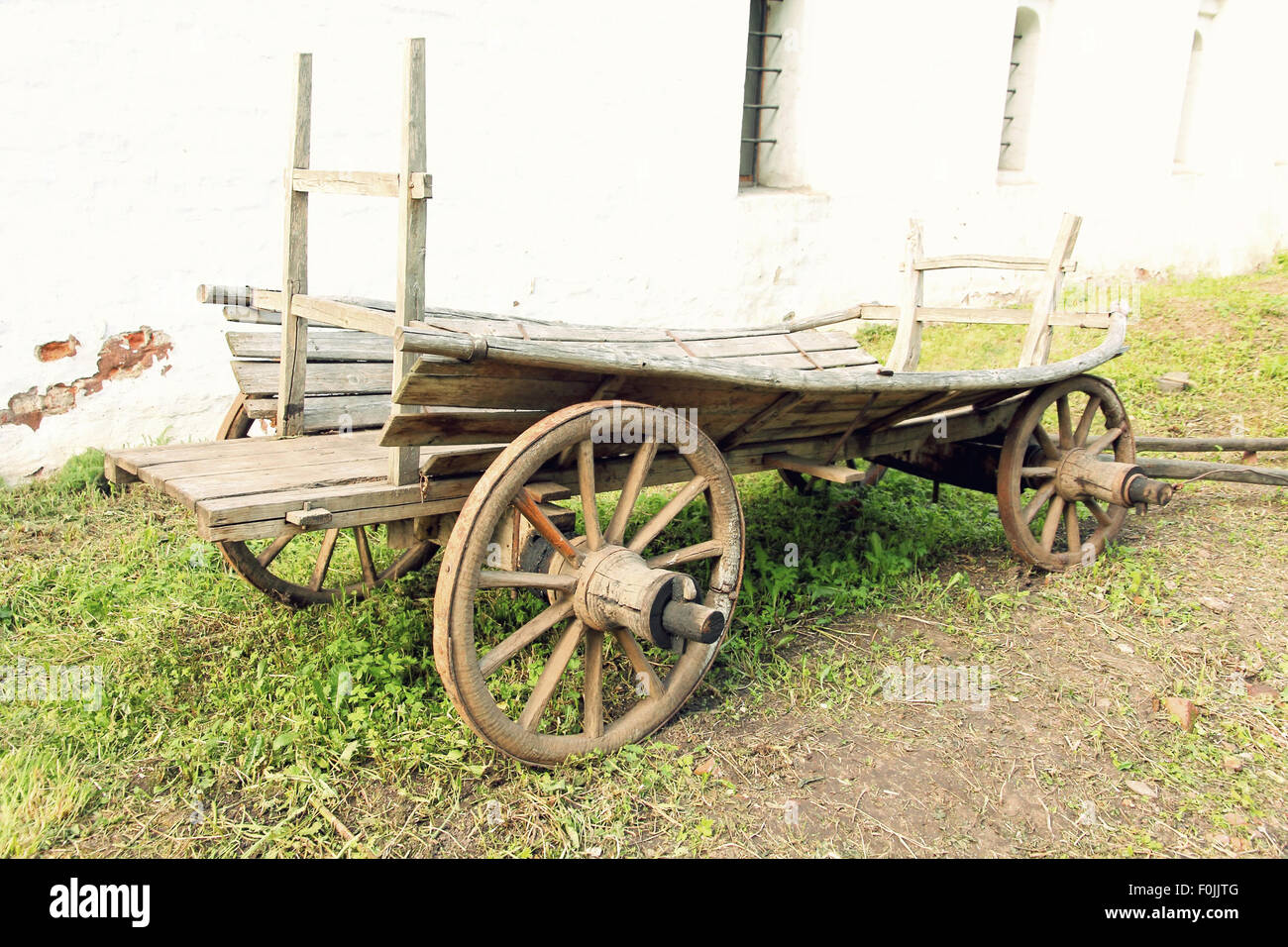 Retrò carrello di legno nella parte anteriore della parete bianca. Foto Stock