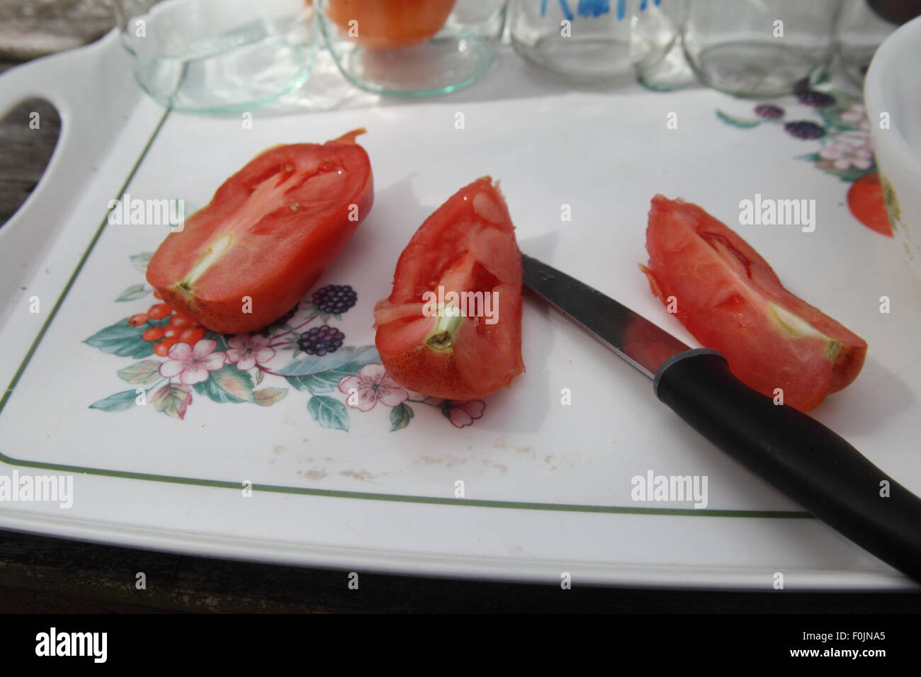Salvataggio di semi di pomodoro Passo 3 tagliare i pomodori in quarti per esporre i semi Foto Stock