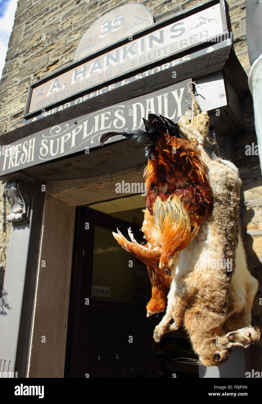Un coniglio morto e polli utilizzato un puntelli nel dramma della BBC il villaggio appendere fuori Hankins fruttivendolo; una location del film, Foto Stock