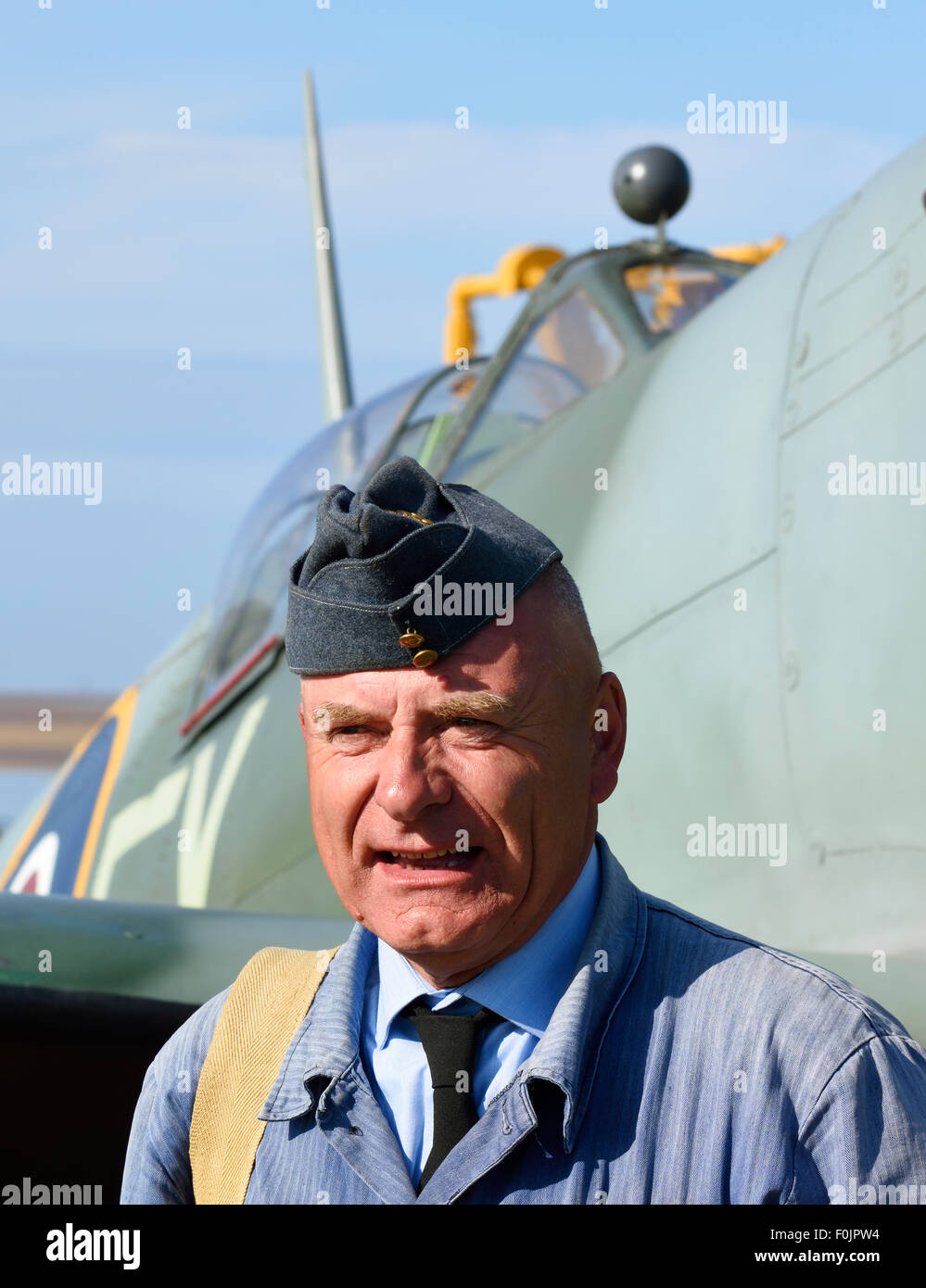 L'uomo negli anni quaranta raf equipaggio a terra uniforme con replica mk 2 spitfire dietro (rievocazione di guerra a lytham, lancashire) Foto Stock