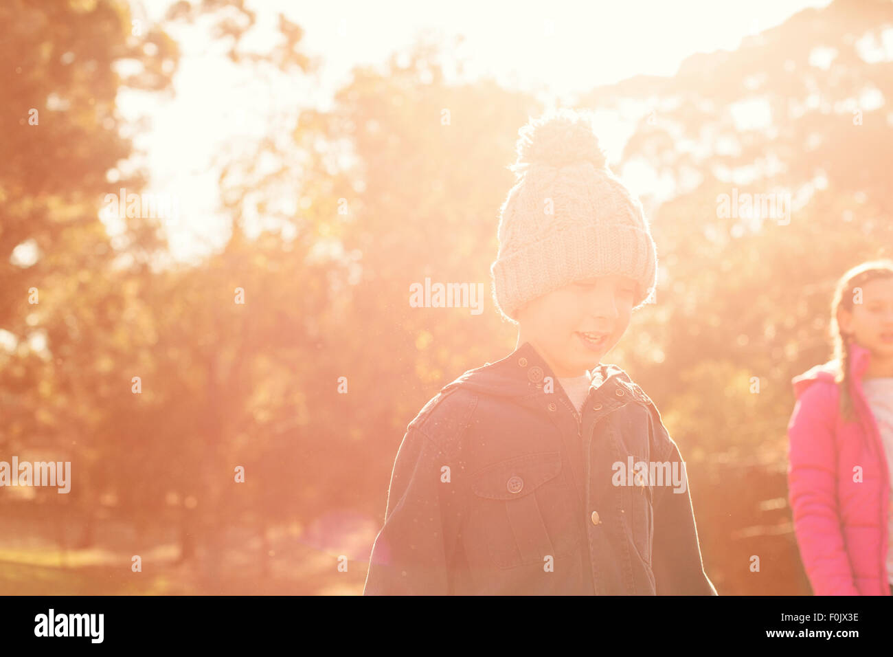 Un ragazzo e una ragazza camminare tra alberi di sole Foto Stock