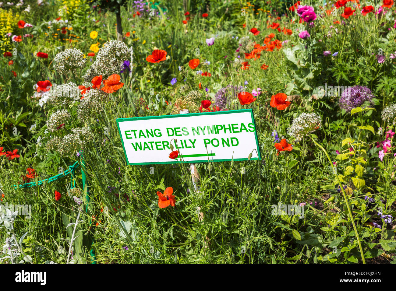 Segno per il laghetto di ninfee in un fiorito confine di papavero, Giverny, il giardino del francese pittore impressionista Claude Monet, Normandia, Francia settentrionale Foto Stock