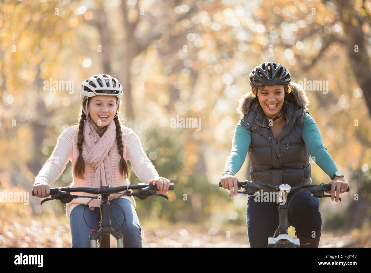 Sorridente madre e figlia in bicicletta all'aperto Foto Stock