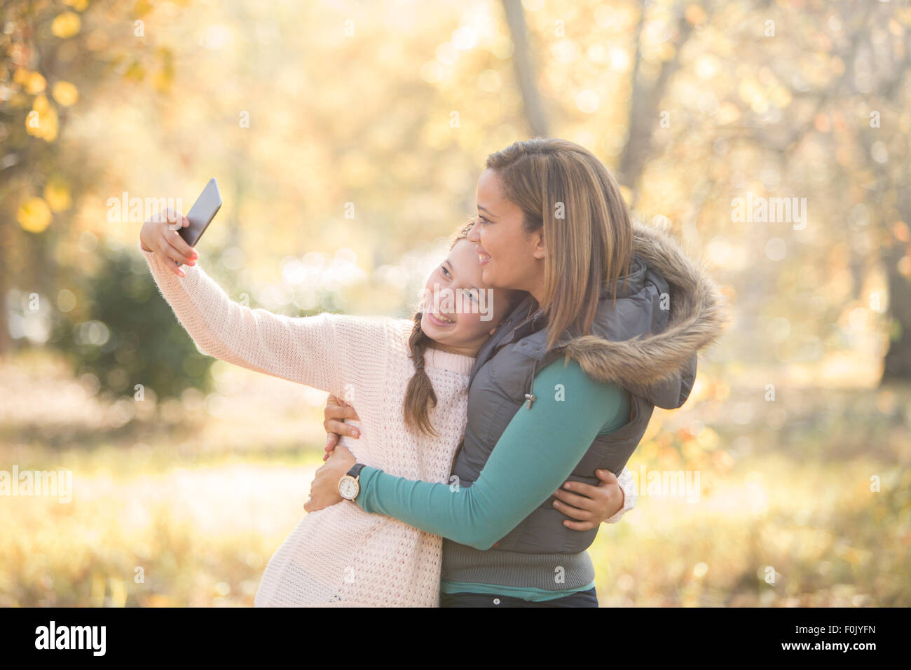 Madre e figlia tenendo selfie all'aperto Foto Stock