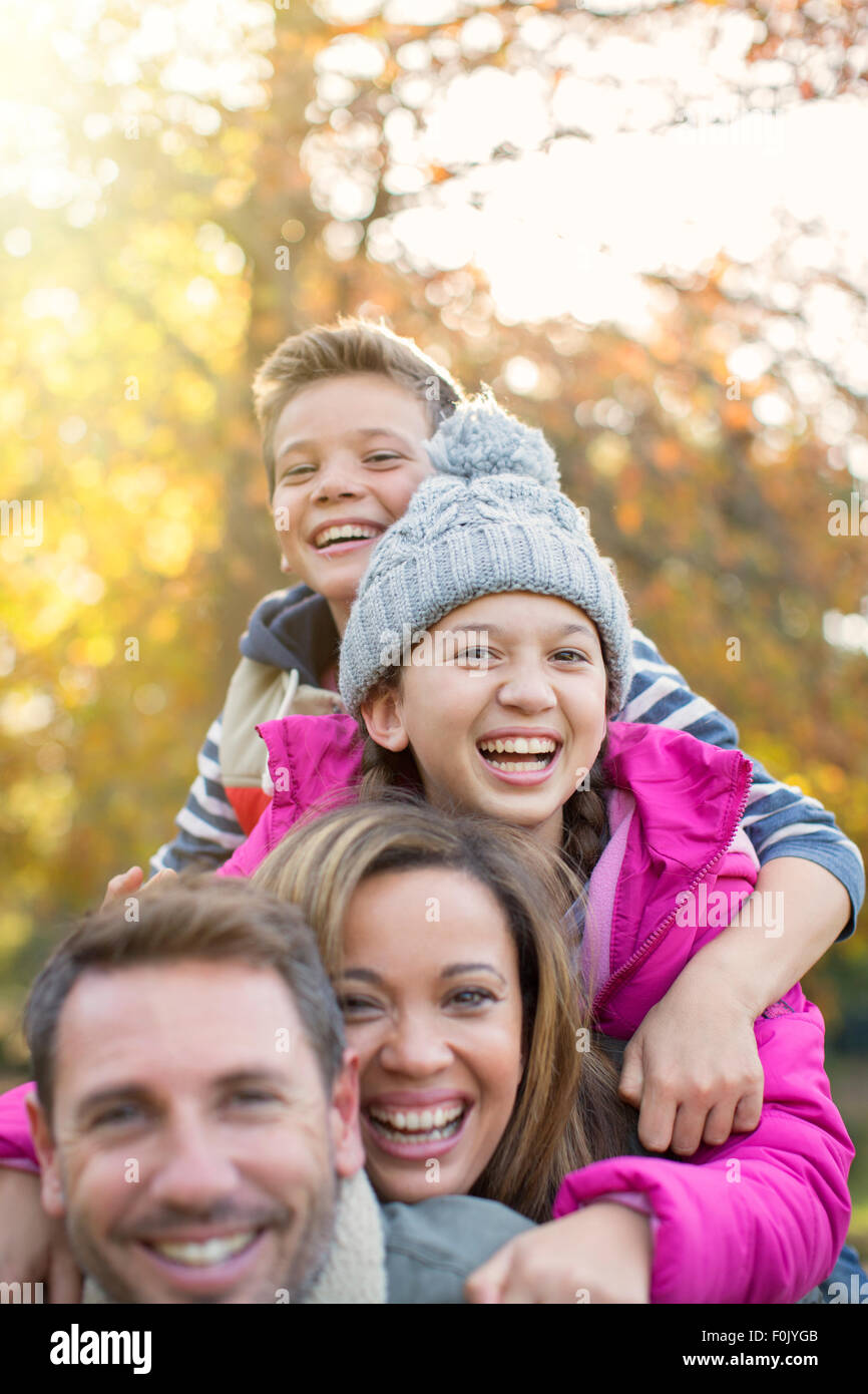 Ritratto di famiglia entusiasta abbracciando all'aperto Foto Stock