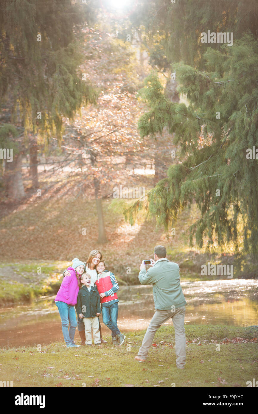 Padre di famiglia di fotografia con la fotocamera del telefono in posizione di parcheggio Foto Stock