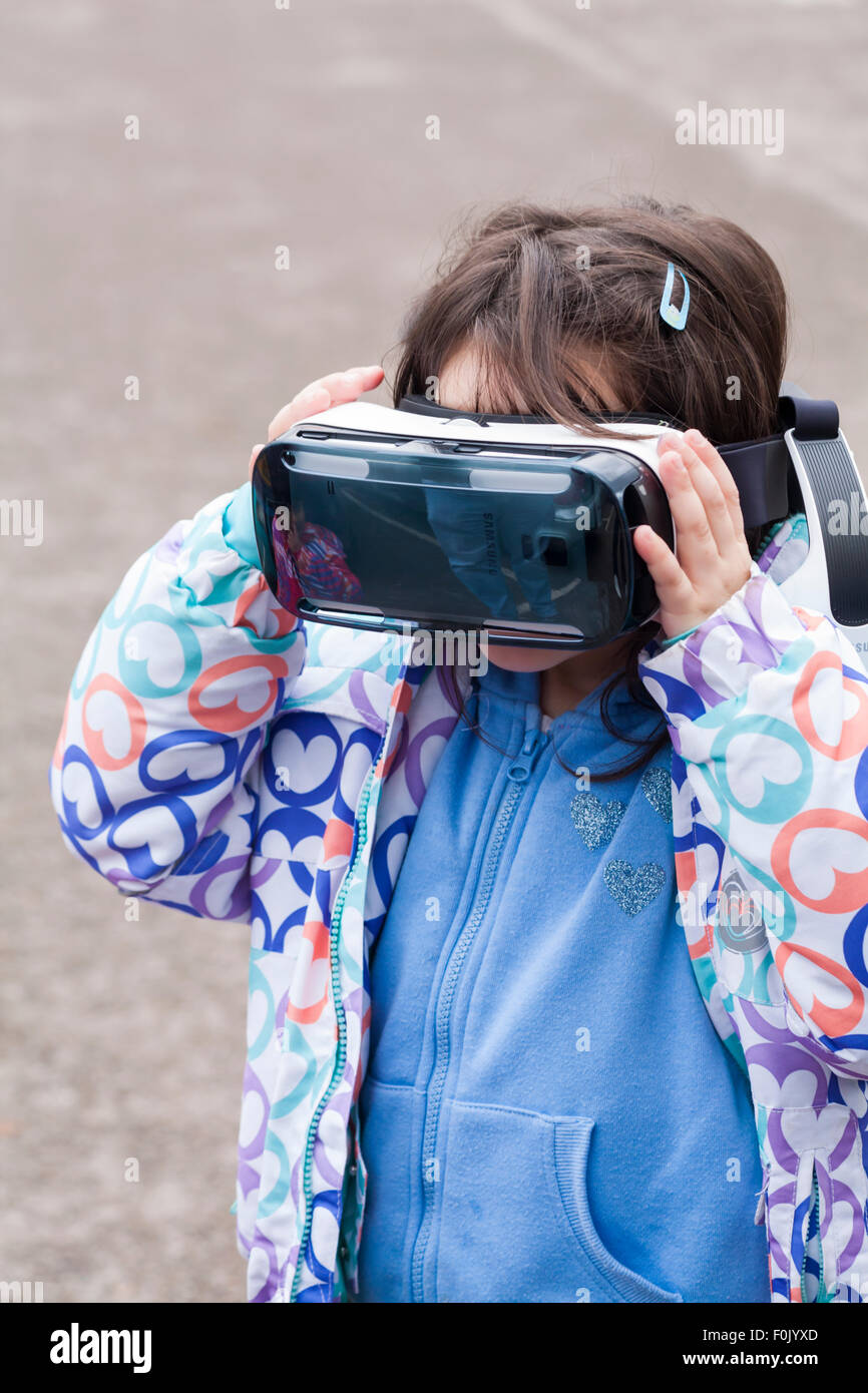 Ragazza che guarda un film sul visore per realtà virtuale Samsung Gear VR - Regno Unito Foto Stock