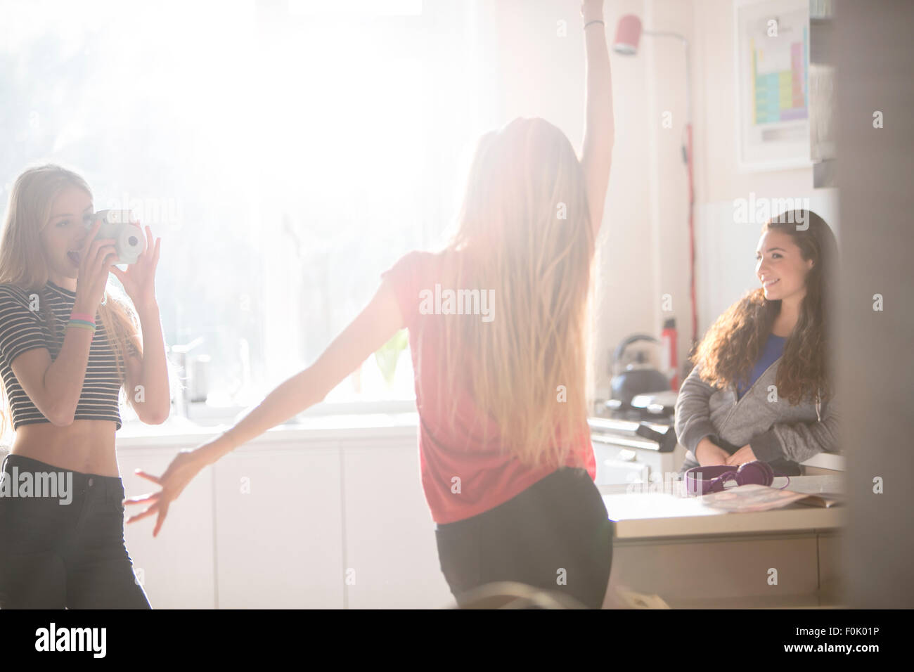 Le ragazze adolescenti dancing e fotografare in cucina Foto Stock
