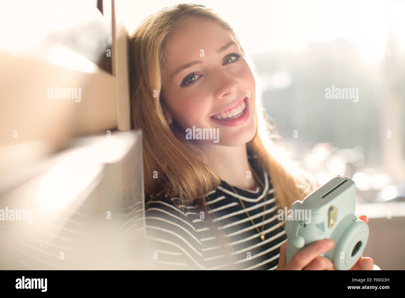 Ritratto sorridente ragazza adolescente con fotocamera istantanea Foto Stock