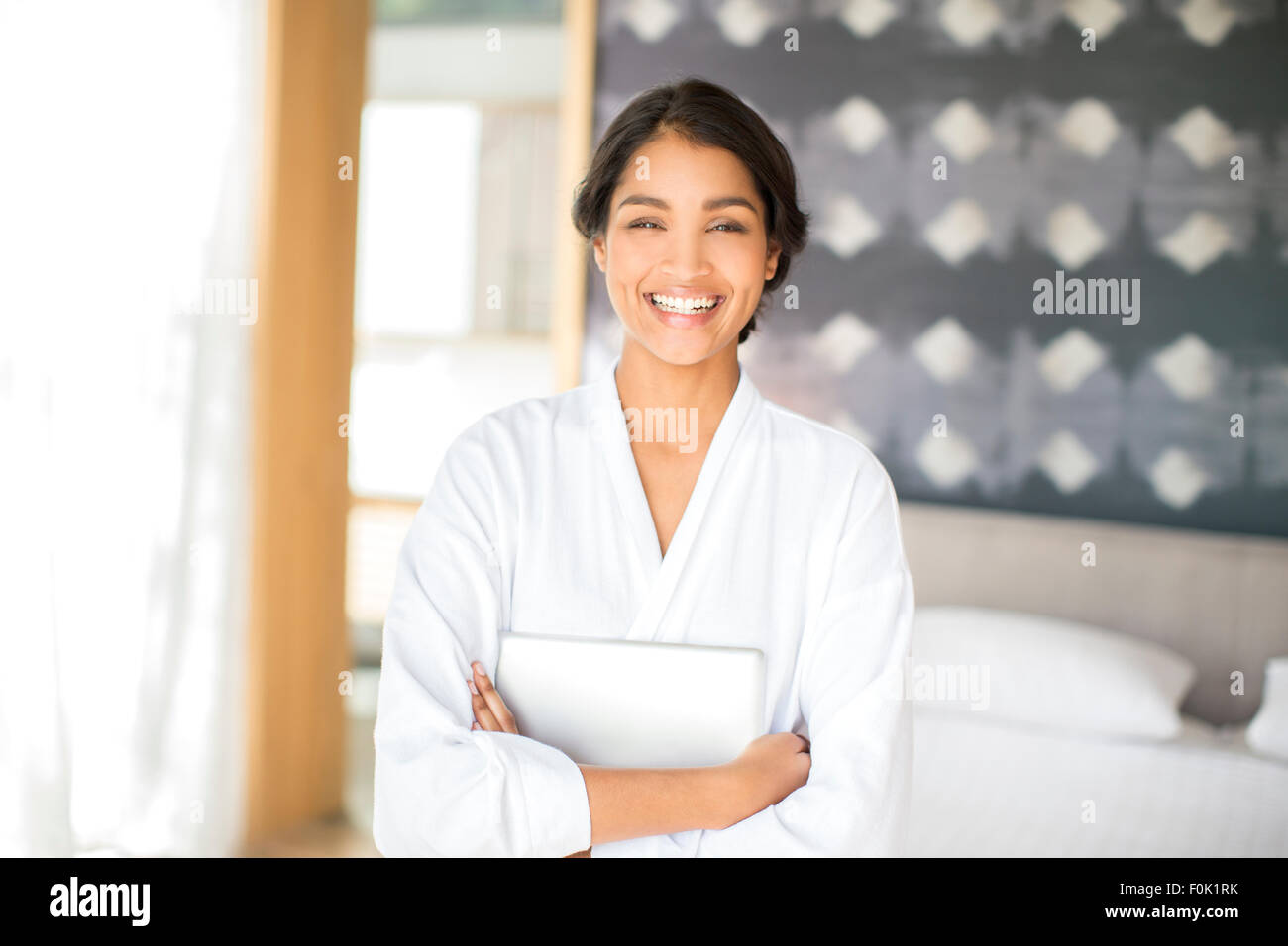 Ritratto di donna sorridente in accappatoio holding tavoletta digitale Foto Stock
