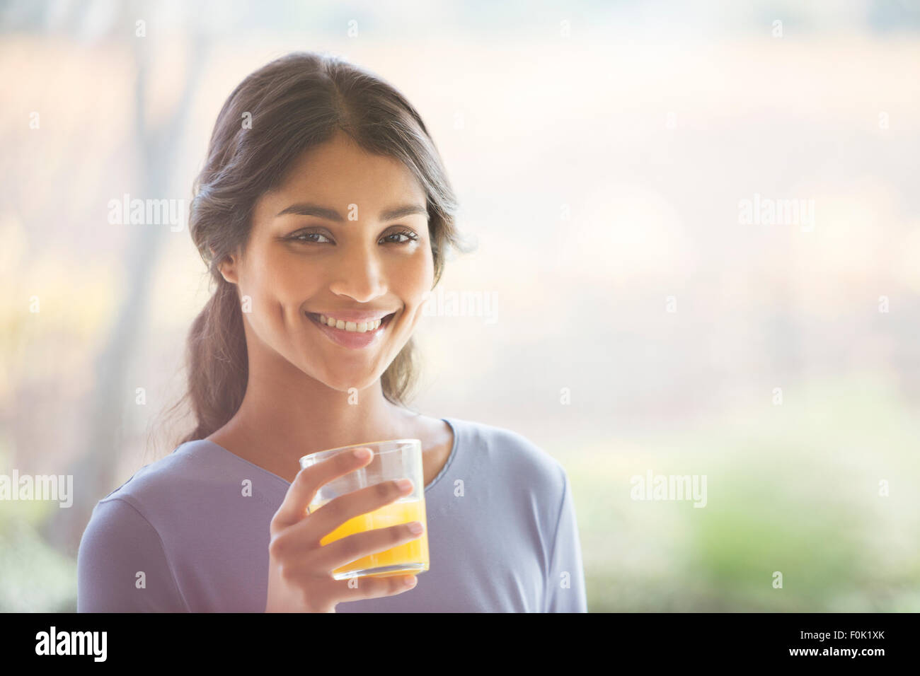 Ritratto di donna sorridente di bere succo di arancia Foto Stock
