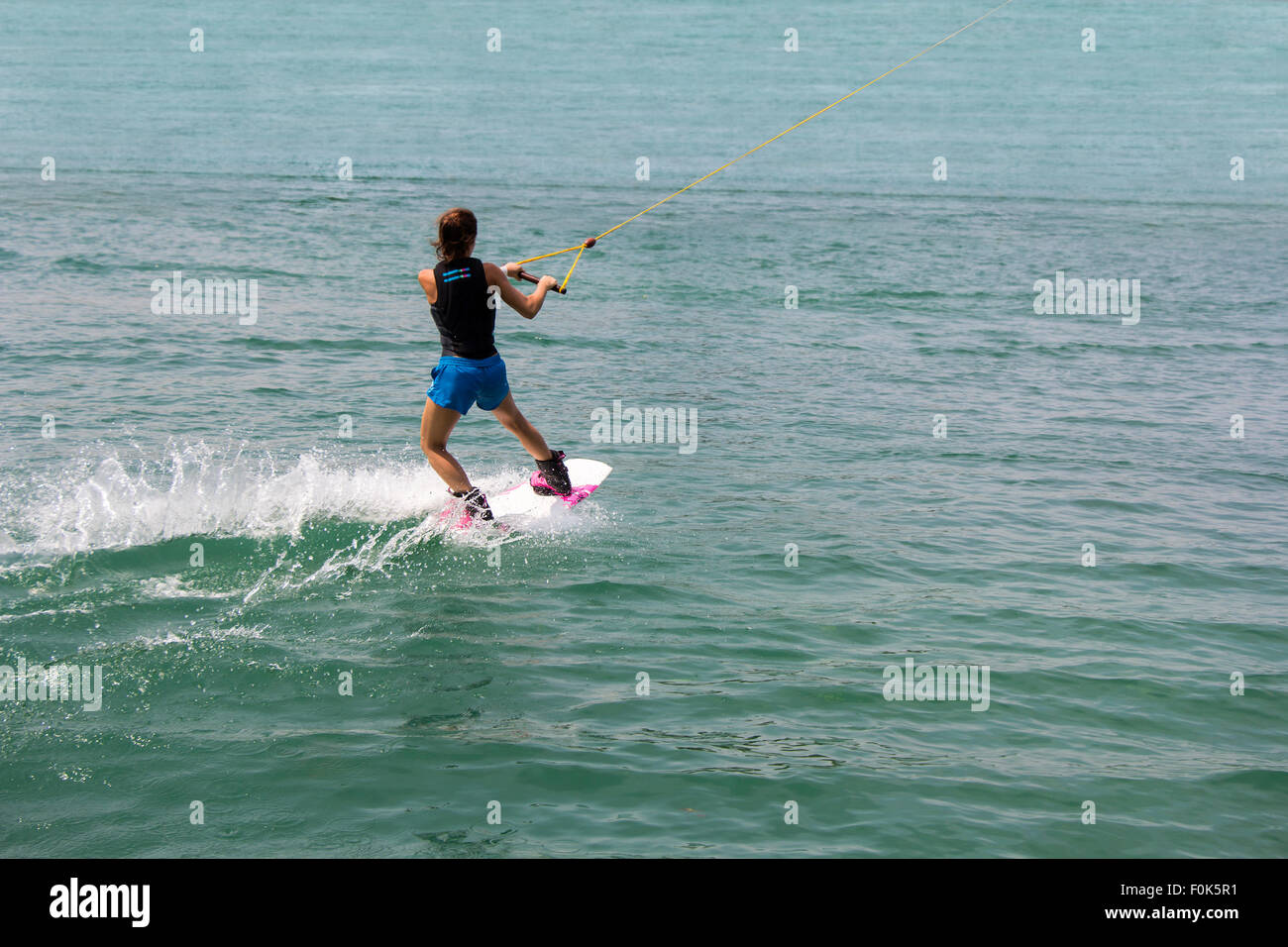 Ragazza giovane wakeboarder in azione sul lago Foto Stock