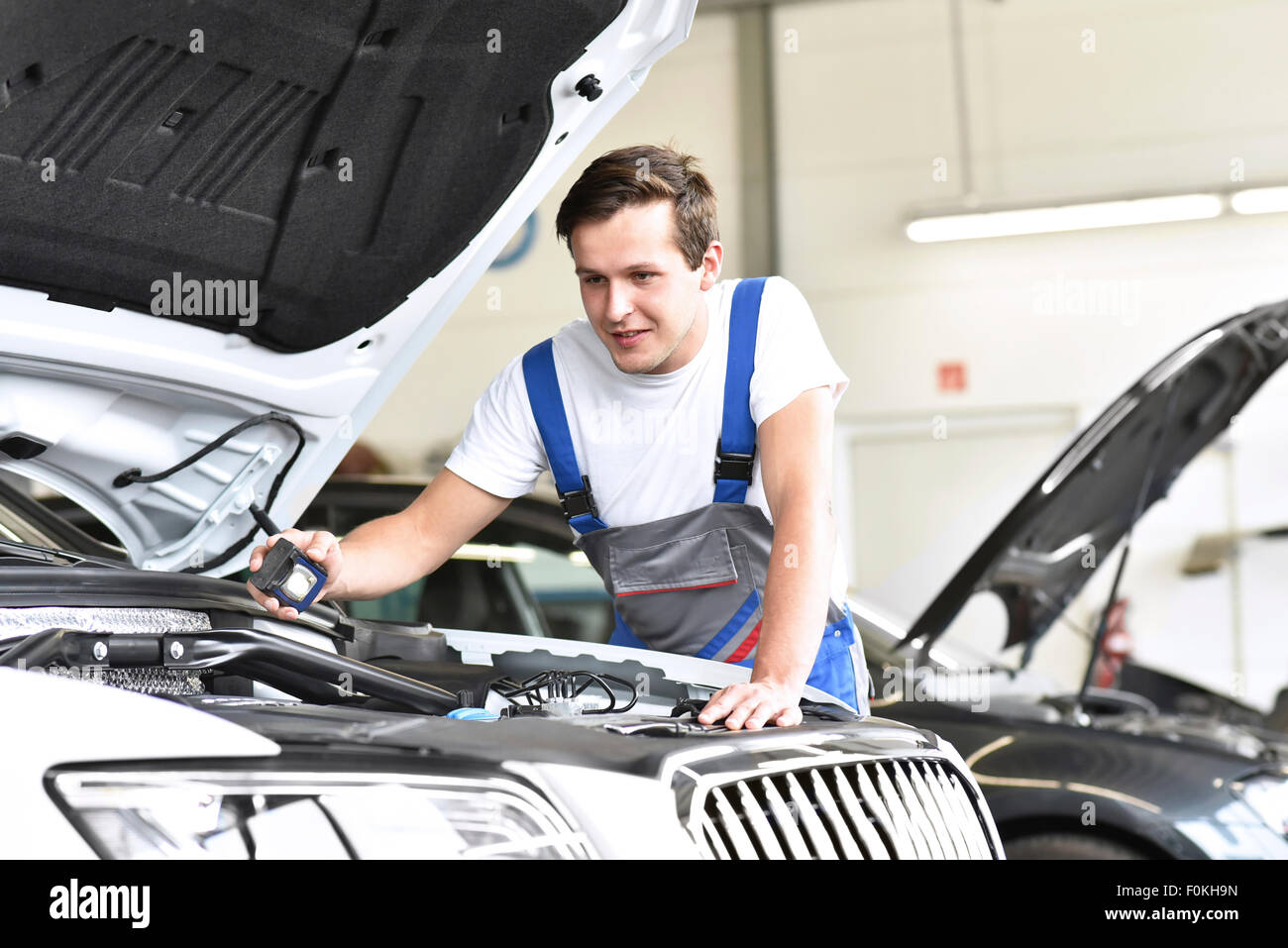 Mechanic esaminando il motore di una vettura in un garage Foto Stock