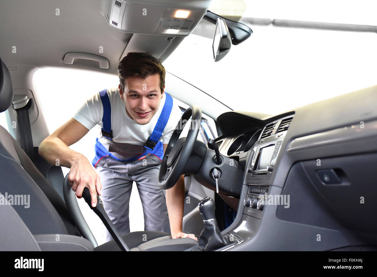 L'uomo hoovering interni per auto Foto Stock