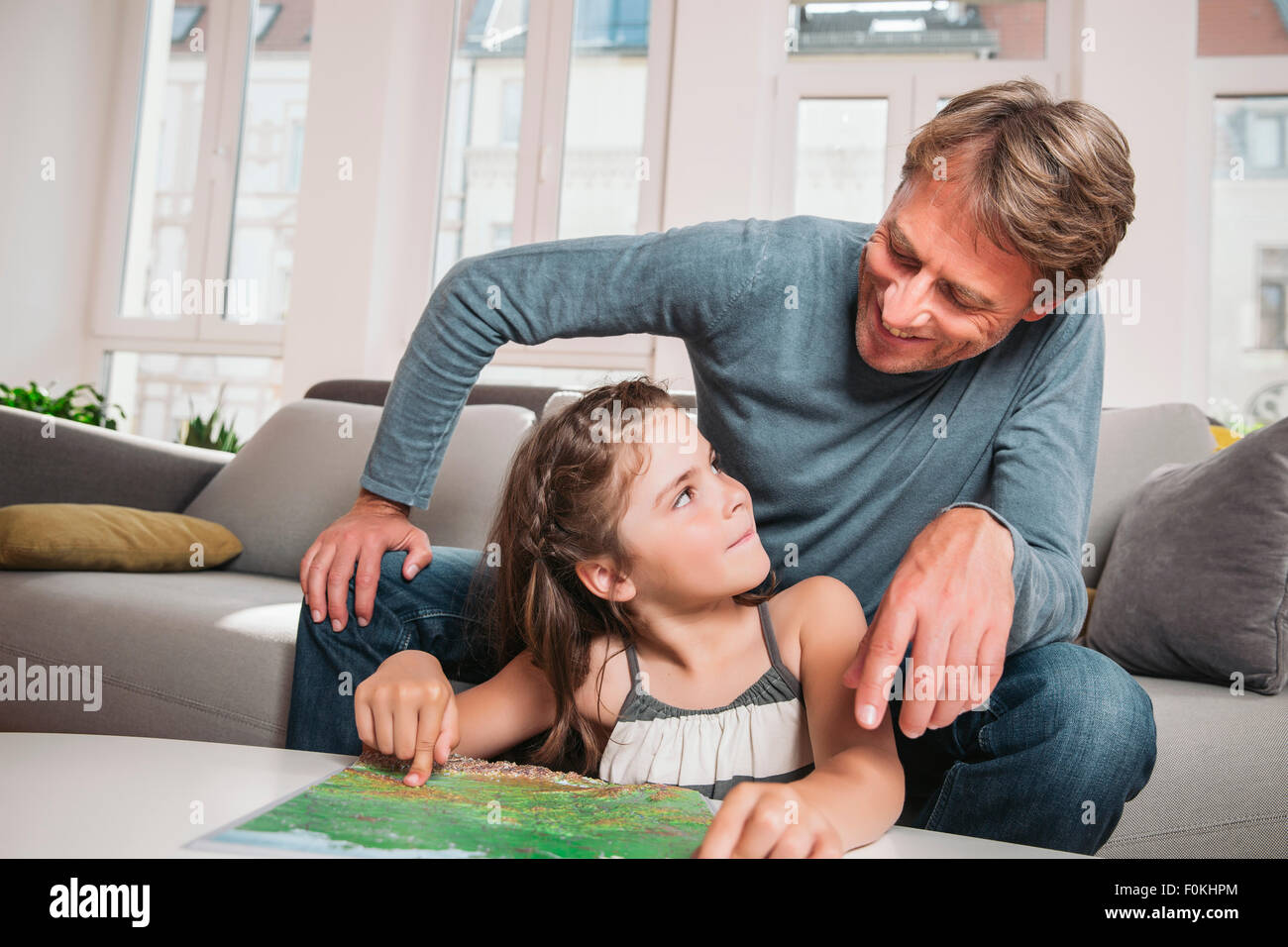 Padre e figlia piccola con mappa nel soggiorno Foto Stock