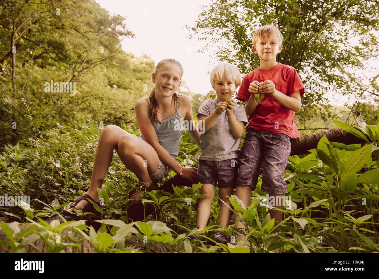 Ritratto di tre bambini sorridenti nella natura Foto Stock