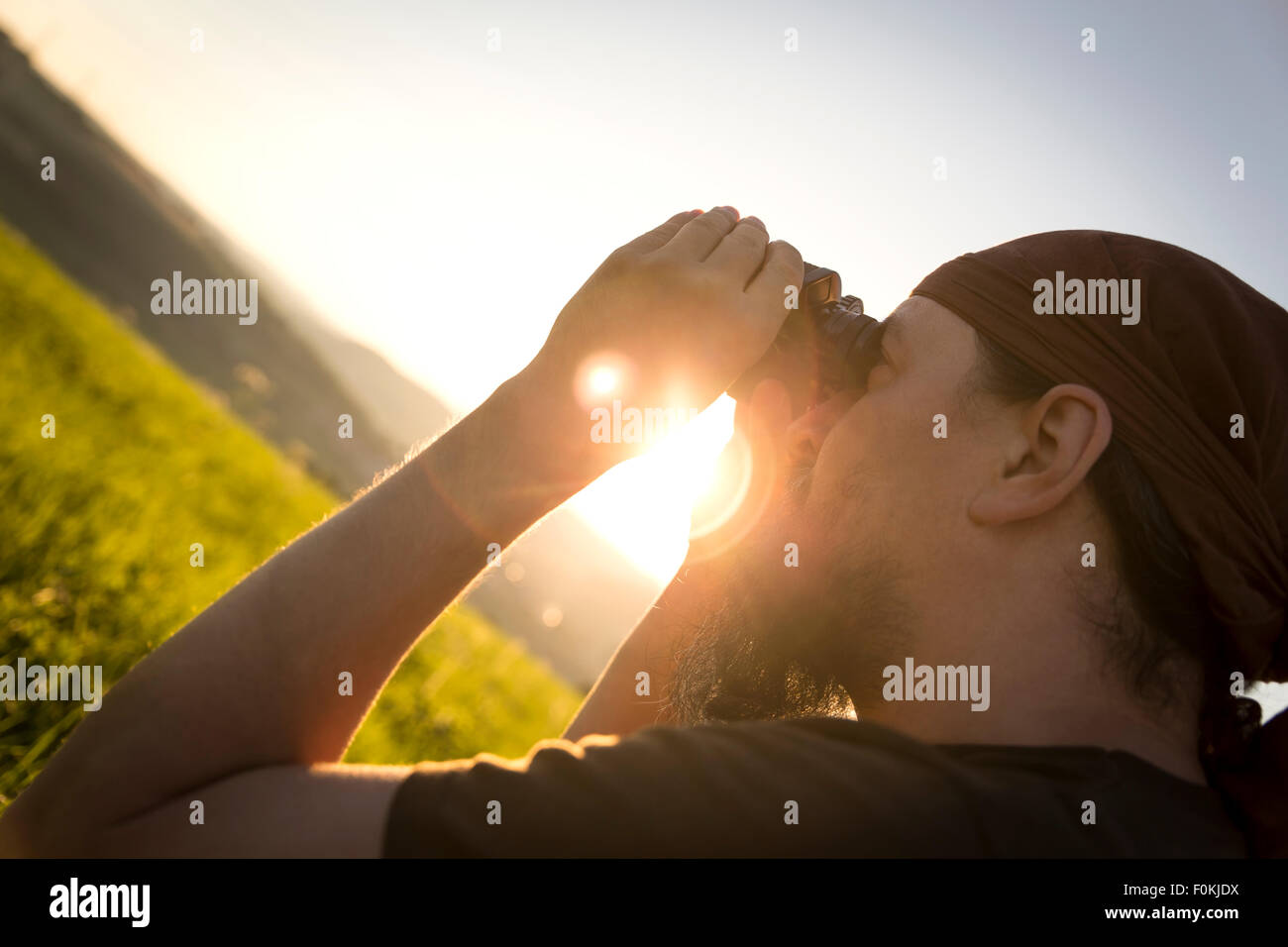 Germania, uomo guardando attraverso il binocolo di sunrise Foto Stock
