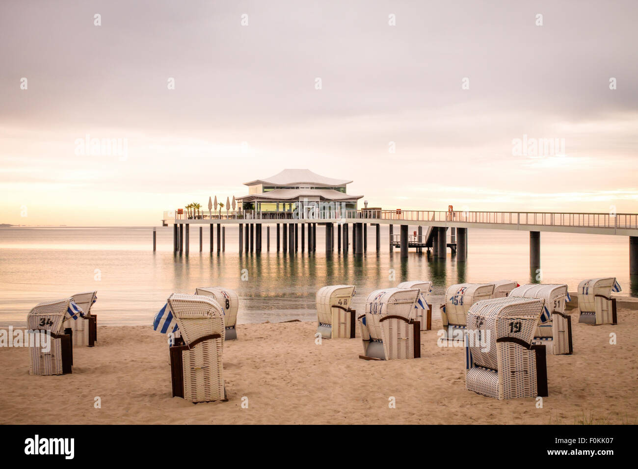 Germania, Niendorf, visualizzare a Timmendorfer Strand con incappucciati sdraio in spiaggia e mare bridge Foto Stock