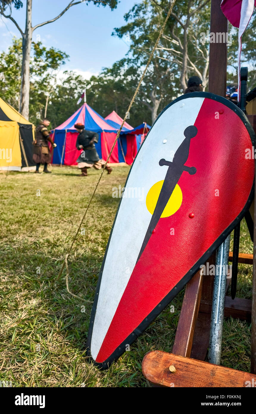Una chiusura di uno scudo medievale con due uomini lotta con la spada in background all'Abbazia Festival medievale in Australia Foto Stock